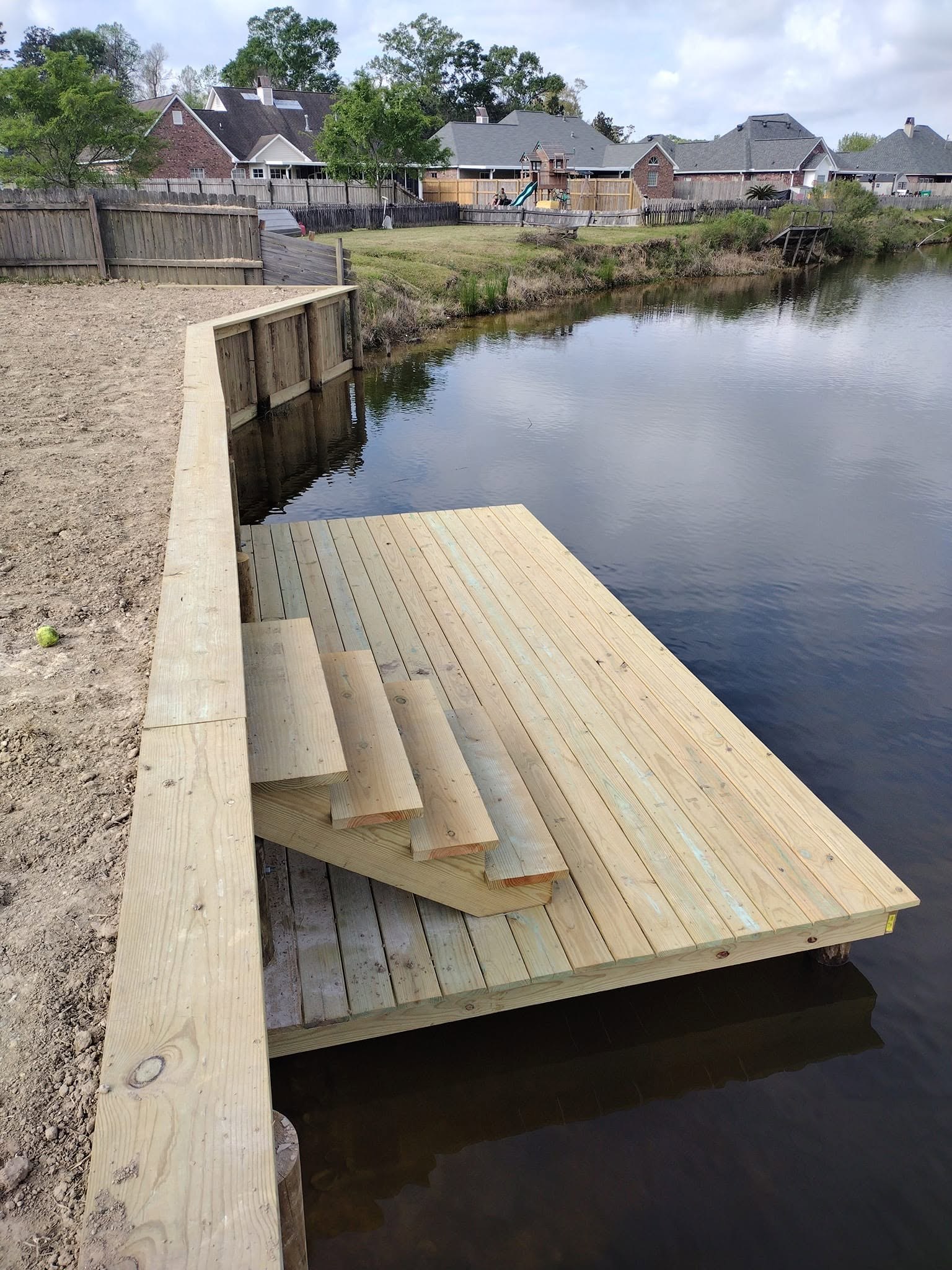Timber bulkhead sea wall built by LA Fence & Bulkheads Newly built treated timber bulkhead sea wall holding a graded shoreline on a South Louisiana waterway
