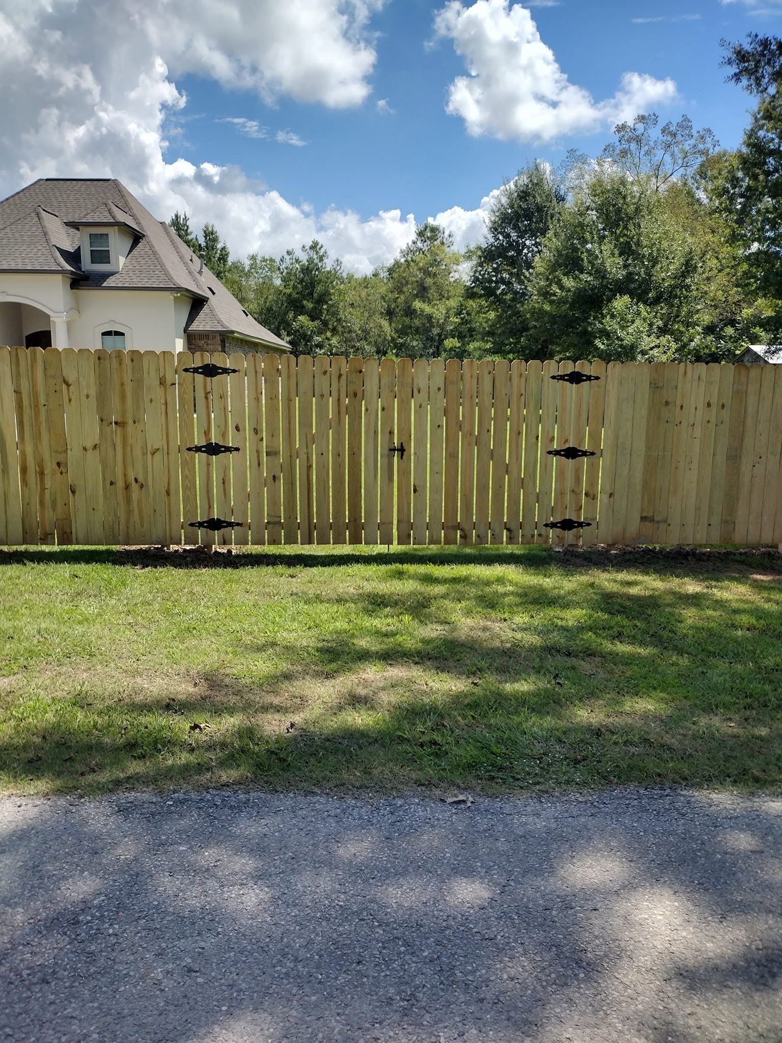 Dog ear privacy fence and gate installation, Louisiana Dog ear wood privacy fence and gate finished with decorative black hinge straps