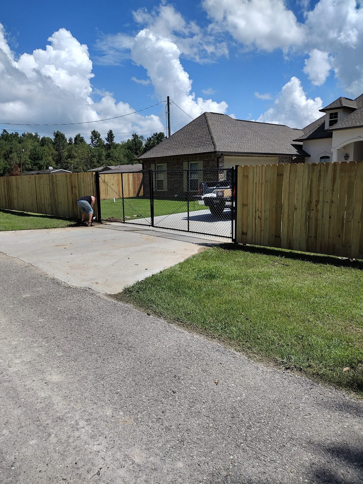 Privacy fence and rolling driveway gate, Louisiana Wood privacy fence with a black chain link rolling driveway gate at a Louisiana home