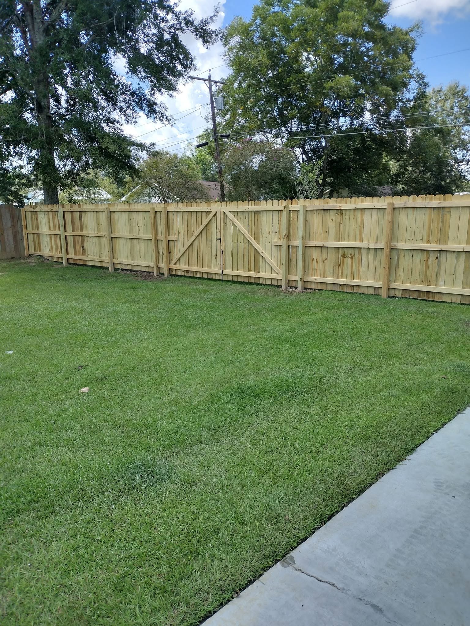 Wood privacy fence with double gate, Baton Rouge Wood privacy fence with a double walk gate enclosing a Baton Rouge backyard